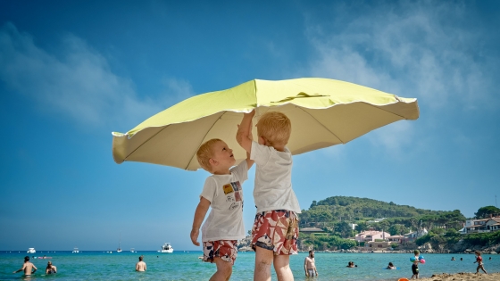 Kinderen onder parasol op het strand
